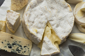 Cheese assorted on a table background. Variety sorts for appetizing, gourmet, delicious snacks. Traditional French dish for wine on lunch and dinner closeup. Camembert, Roquefort.