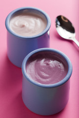 Yogurts assortment  in ceramic bowls on colorful background. Natural and fruit healthy, diet, gourmet dessert for granola breakfast. Sweet yogurts closeup.