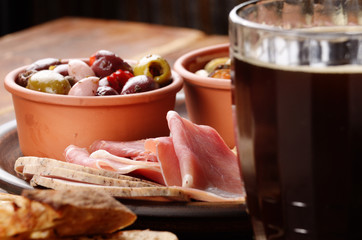 Tapas of salmon, mussels, jamon and olives with beer
