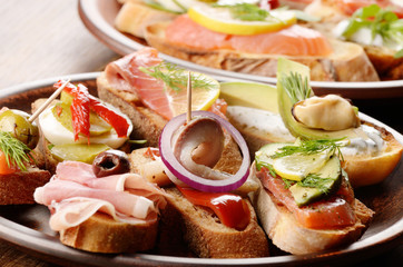 Open sandwiches with salmon, eggs, mussels, jamon and herring