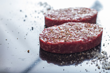 Meat for burgers, grilling, barbecue, bbq. Fresh, spicy, uncooked, delicious beef for hamburgers on dark background with copy space closeup