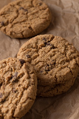 Cookies pile with chocolate chip on light textile background. Delicious morning snacks for breakfast, brunch and lunch. Appetizing, healthy, sweet, scrummy, and fast food.