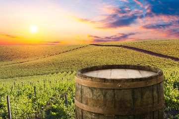 Red wine with barrel on vineyard in green Tuscany, Italy