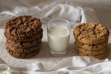 Cookies pile with chocolate chip on light textile background. Delicious morning snacks for breakfast, brunch and lunch. Appetizing, healthy, sweet, scrummy, and fast food.