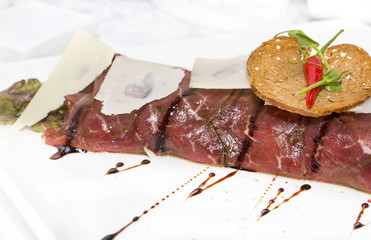 Slices of salmon with herbs and cheese on a white plate
