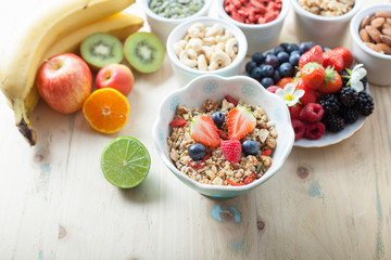 Paleo style breakfast: gluten free grain free oat free granola with mixed nuts, and fresh berries and fruits, selective focus