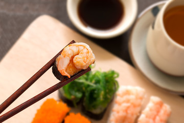 Sushi set with chop sticks, wasabi served on wooden slate, selec