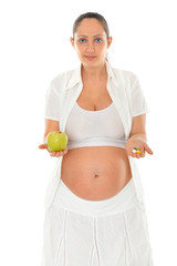 Pregnant young woman with apple and pills in hand, close up