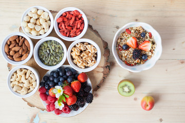 Paleo style breakfast: gluten free grain free oat free granola with mixed nuts, and fresh berries and fruits, selective focus