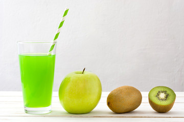 Green smoothie with apple and kiwi on a white wooden table and white background

