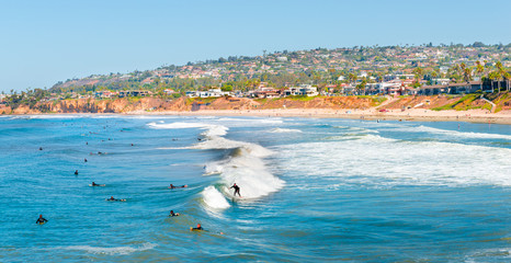 Summer fun. Coast San Diego, California. Surfers in the ocean waiting for a wave. - obrazy, fototapety, plakaty