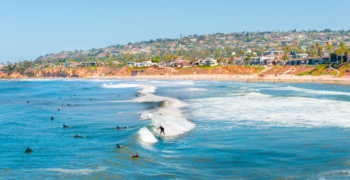 Summer fun. Coast San Diego, California. Surfers in the ocean waiting for a wave.
