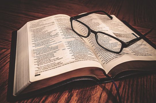 Open Study Bible On Table With Glasses