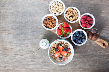 Paleo style breakfast: grain free oat free granola  with almond milk and with mixed nuts, and fresh berries, top view, selective focus