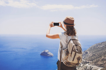 Hiking woman using smart phone taking photo
