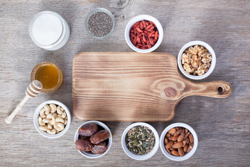 Grain free oat free paleo granola ingredients: mixed nuts, seeds, goji berries, chia, honey and coconut oil, selective focus