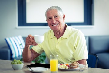Senior man having tea with breakfast 