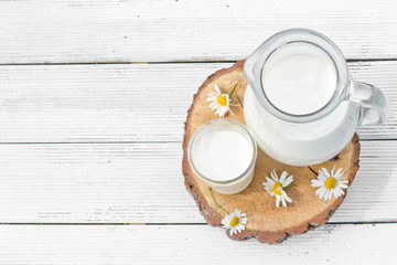 Milk jug and glass with chamomiles