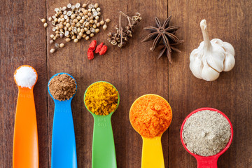 Various colorful spices on wooden table