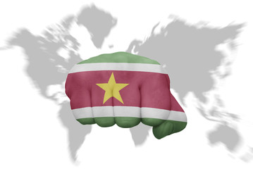 fist with the national flag of suriname on a world map background