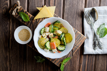 Plate with the fried vegetable marrows salmon salad on rustic table
