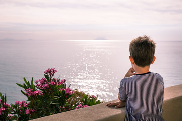 child looking at the sparkling sea water
