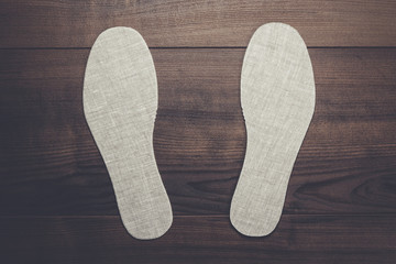 grey insoles for shoes over wooden background