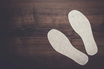 grey insoles for shoes over wooden background