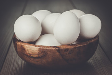 some eggs in wooden bowl on the table