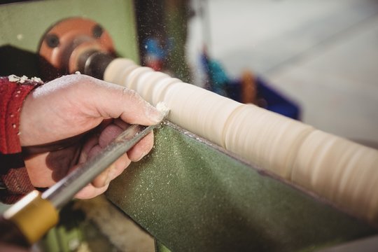 Carpenter sculpting a wood piece