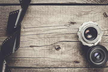 retro camera lenses and negative film on wooden table