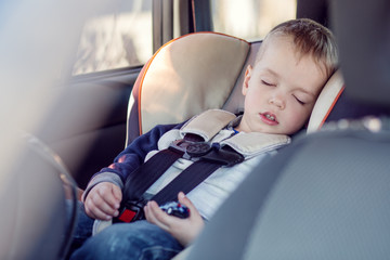 cute little boy sleeping in car