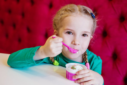 little girl eating ice cream in cafe
