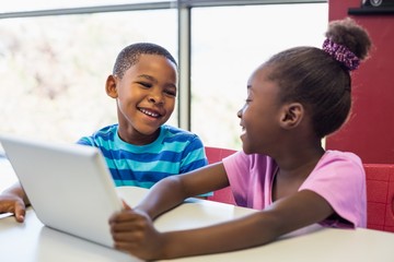 School kids using a digital tablet in classroom