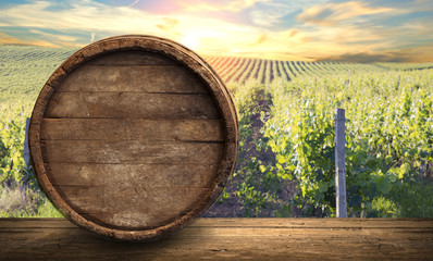 Red wine with barrel on vineyard in green Tuscany, Italy