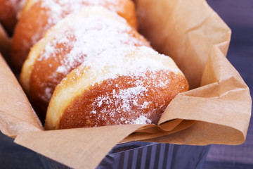 German donuts - berliner with icing sugar in a box on a dark wooden background