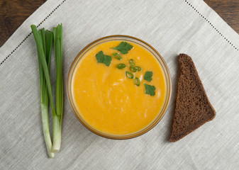 Pumpkin soup with spring onion and piece of bread