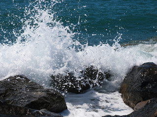 Fototapeta premium Sea wave crashing on rocks on the beach