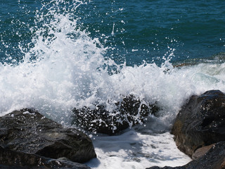 Sea wave crashing on rocks on the beach