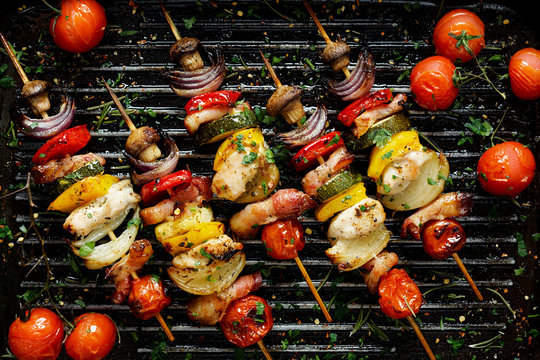 Grilled vegetable and meat skewers in a herb marinade on a grill pan, top view