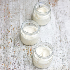 Three glass jars with milk on white background