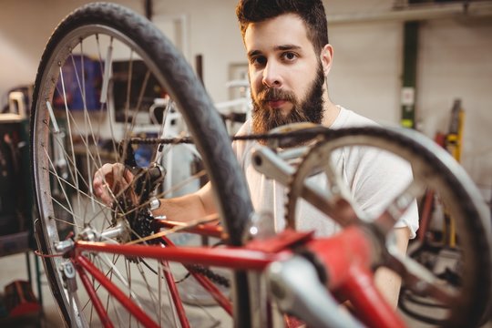 Portrait of hipster repairing a bicycle