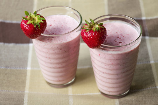 Fresh strawberry smoothie - spring cockail decorated with fresh red strawberries. Sweet spring drink full of vitamin.
