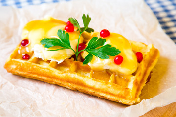 Belgian waffle with sauce, fried egg and parsley