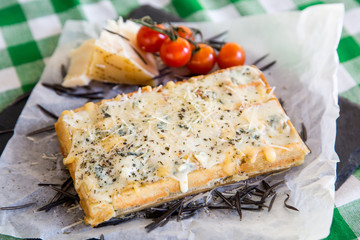 Belgian waffle with sauce, Parmesan cheese, rosemary and cherry tomatoes