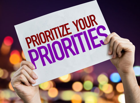 Prioritize Your Priorities placard with night lights on background