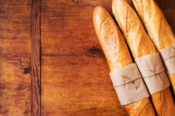 Fresh and crispy French bread on a wooden table with copy space on left