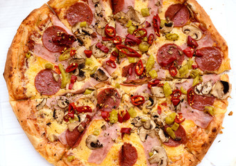 Pepperoni pizza with ham, red peppers and cheese