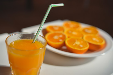 Top view on juice and slices of orange on white plate background