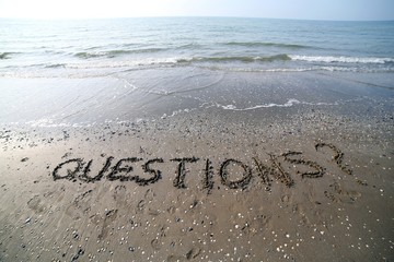Word QUESTIONS written in large letters on the sand